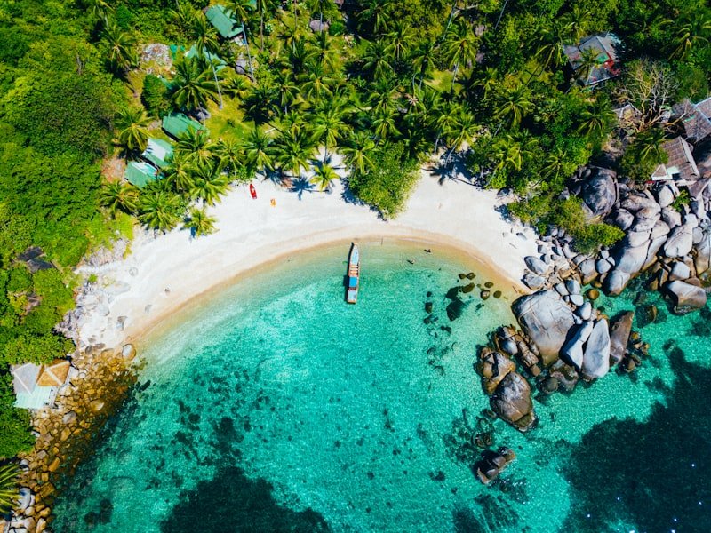 A long-tail boat anchored in a hidden tropical bay